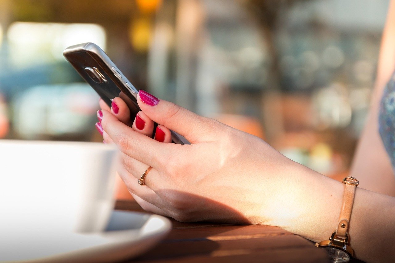 Hands holding a smartphone showing a conversation interface